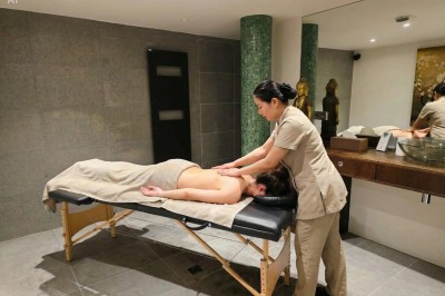 Table extérieure dressée avec des verres à vin, des fleurs, des bougies et des plateaux de nourriture.