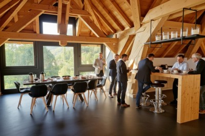 Table extérieure dressée avec des verres à vin, des fleurs, des bougies et des plateaux de nourriture.