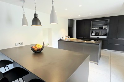 Table extérieure dressée avec des verres à vin, des fleurs, des bougies et des plateaux de nourriture.