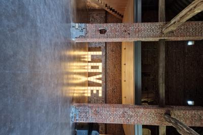 Miniature Location salle Assesse (Province de Namur) - Château Vivier l’Agneau et La Grange #11 Mur en briques avec le mot ’LIVE’ illuminé, situé dans un espace intérieur avec poutres en bois et sol en béton.