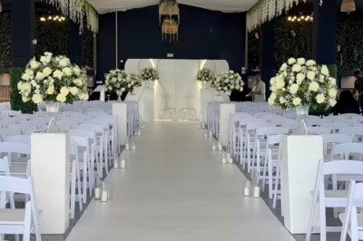 Un couple en tenue de mariage se tient devant un bâtiment élégant sous un ciel dégagé.