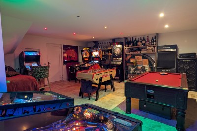 Batterie installée sur une scène éclairée, entourée d'amplificateurs et de structures métalliques.