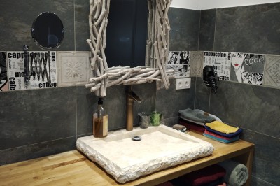 Batterie installée sur une scène éclairée, entourée d'amplificateurs et de structures métalliques.