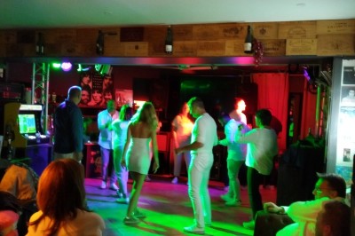 Batterie installée sur une scène éclairée, entourée d'amplificateurs et de structures métalliques.