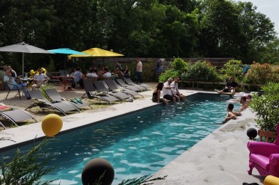 Batterie blanche installée sur une scène éclairée, entourée d'amplificateurs et de structures métalliques.