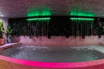 Batterie blanche installée sur une scène éclairée, entourée d'amplificateurs et de structures métalliques.