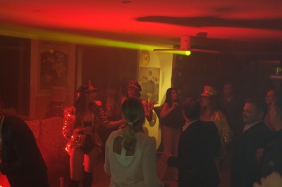 Batterie blanche installée sur une scène éclairée, entourée d'amplificateurs et de structures métalliques.