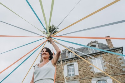 Un couple danse sous des lumières colorées et une ambiance de fumée lors d'une réception festive.