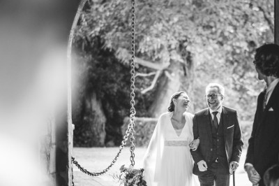 Un couple danse sous des lumières colorées et une ambiance de fumée lors d'une réception festive.