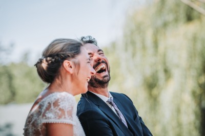 Un couple danse sous des lumières colorées et une ambiance de fumée lors d'une réception festive.