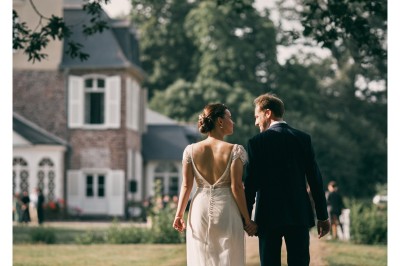 Un couple danse sous des lumières colorées et une ambiance de fumée lors d'une réception festive.