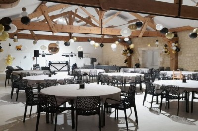 Miniature Location salle Les Mathes (Charente-Maritime) - Logis de la Palmeraie #11 Salle de réception décorée pour un anniversaire, avec tables alignées, guirlandes et lanternes suspendues au plafond en bois.