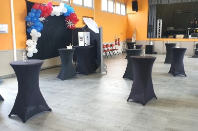 Borne photo avec éclairage, clavier et imprimante posée sur des tables noires dans un espace intérieur.