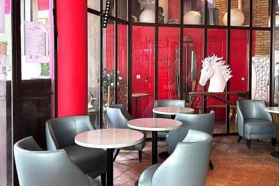 Buste masculin noir sans tête, orné de motifs colorés, exposé devant un rideau rouge et un piano en arrière-plan.