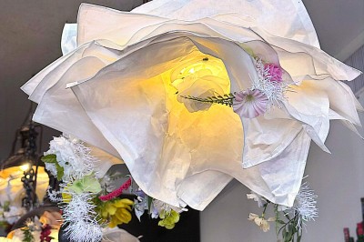 Buste masculin noir sans tête, orné de motifs colorés, exposé devant un rideau rouge et un piano en arrière-plan.