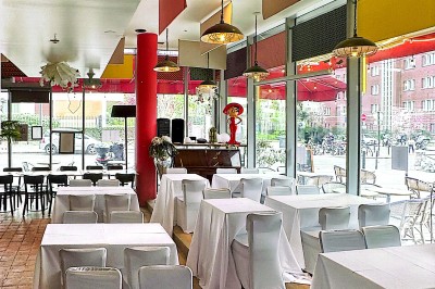 Buste masculin noir sans tête, orné de motifs colorés, exposé devant un rideau rouge et un piano en arrière-plan.