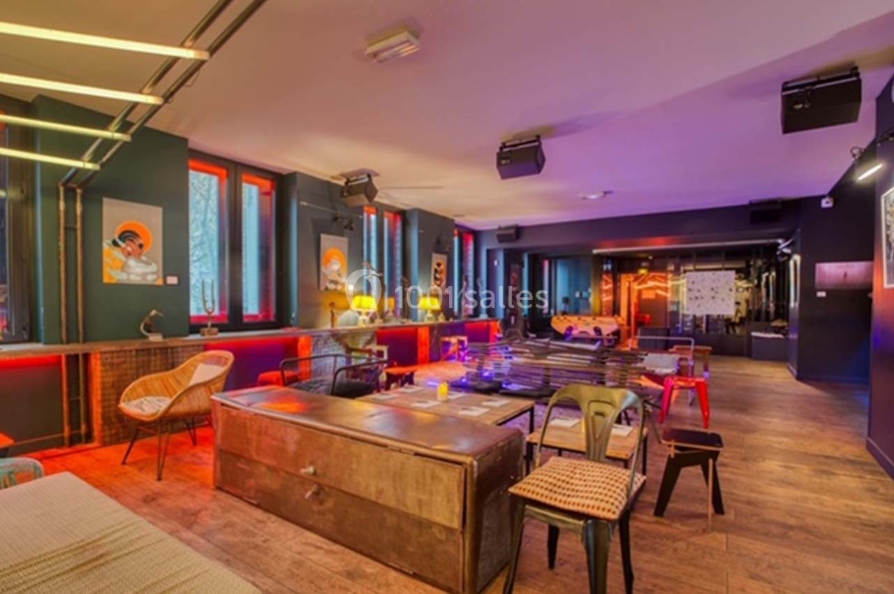 Salle moderne avec mobilier éclectique, éclairage tamisé et décorations murales colorées.