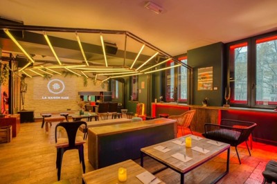 Escalier intérieur avec murs sombres décorés de néons roses et motifs géométriques, éclairage tamisé.