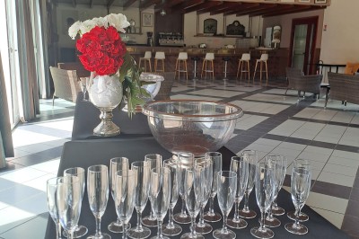 Pelouse verte entourée de bâtiments en briques et crépi, avec arbres et allée en béton sous un ciel dégagé.