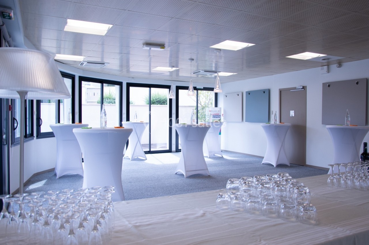 Location salle Mont-de-Marsan (Landes) - Cci des Landes #12 Salle lumineuse aménagée pour un événement, avec des tables hautes drapées de blanc et des verres disposés au premier plan.