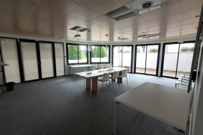 Paniers de viennoiseries avec jus d'orange et cafetière en arrière-plan dans une salle lumineuse.