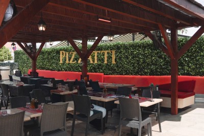 Miniature Location salle Villeneuve-Loubet (Alpes-Maritimes) - Pizzatti Villeneuve Loubet #3 Des personnes dînent dans un restaurant à l'ambiance chaleureuse, assises à des tables rondes avec nappes rouges.