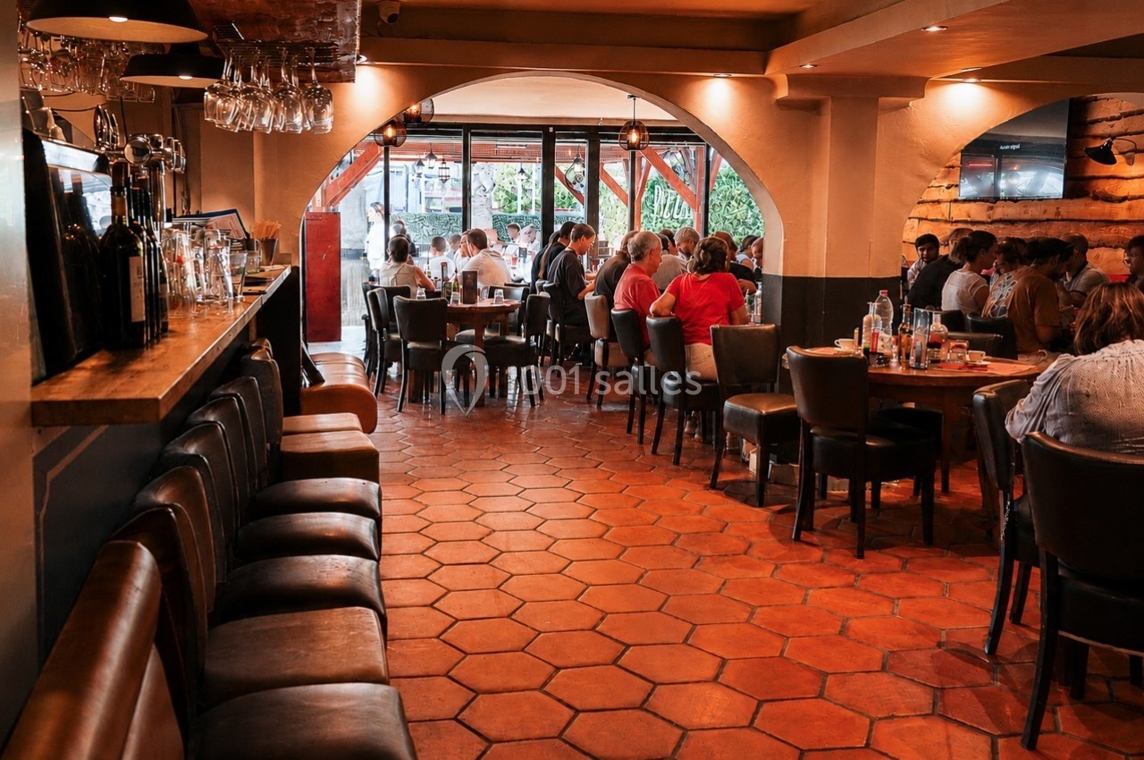 Location salle Villeneuve-Loubet (Alpes-Maritimes) - Pizzatti Villeneuve Loubet #7 Salle de restaurant animée avec des clients assis à des tables, éclairage chaleureux et sol en carreaux orange.