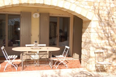Tente de style yourte avec terrasse en bois, entourée d'arbres dans un cadre naturel.