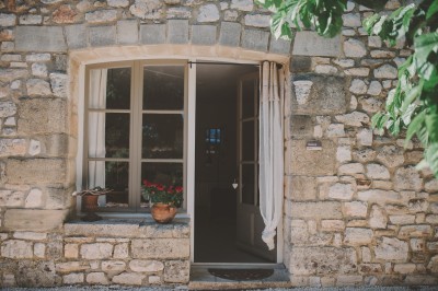 Tente de style yourte avec terrasse en bois, entourée d'arbres dans un cadre naturel.