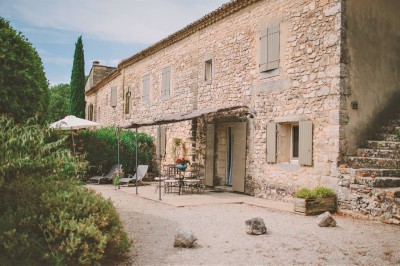 Tente de style yourte avec terrasse en bois, entourée d'arbres dans un cadre naturel.