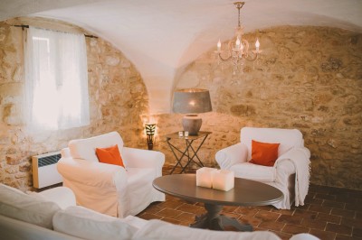 Tente de style yourte avec terrasse en bois, entourée d'arbres dans un cadre naturel.
