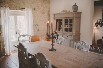 Tente de style yourte avec terrasse en bois, entourée d'arbres dans un cadre naturel.