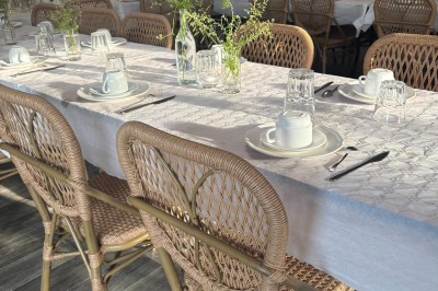 Tente de style yourte avec terrasse en bois, entourée d'arbres dans un cadre naturel.