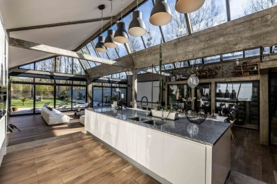 Mur en briques décoré de miroirs et d'une porte en bois sculpté, avec des canapés colorés en premier plan.