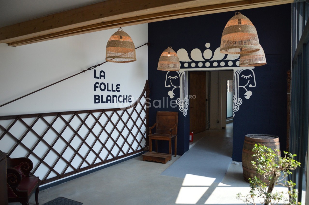 Entrée d'un espace intérieur avec des lampes suspendues, une décoration murale et un tonneau en bois.