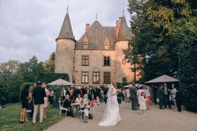 Miniature Location salle Vinzelles (Puy-de-Dôme) - Château de Sauvagnat #2 Voiture décapotable verte décorée de fleurs devant un château, avec des invités en arrière-plan.