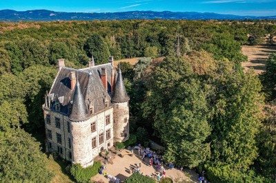 Miniature Location salle Vinzelles (Puy-de-Dôme) - Château de Sauvagnat #13 Voiture décapotable verte décorée de fleurs devant un château, avec des invités en arrière-plan.
