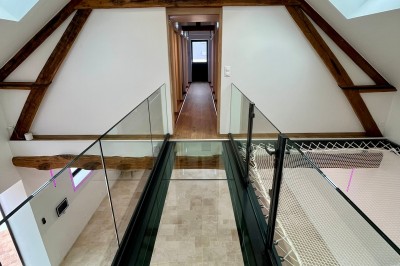 Table de ping-pong en extérieur devant un bâtiment en pierre avec une enseigne ’Le Loft de la Grange’.