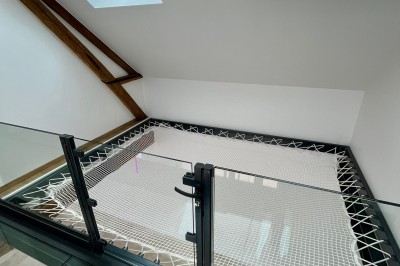 Table de ping-pong en extérieur devant un bâtiment en pierre avec une enseigne ’Le Loft de la Grange’.