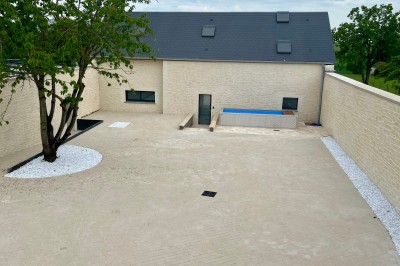 Table de ping-pong en extérieur devant un bâtiment en pierre avec une enseigne ’Le Loft de la Grange’.