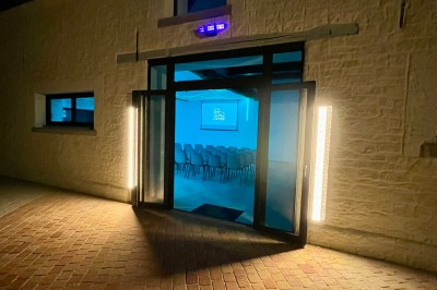 Table de ping-pong en extérieur devant un bâtiment en pierre avec une enseigne ’Le Loft de la Grange’.