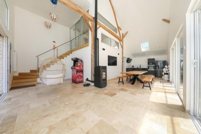 Table de ping-pong en extérieur devant un bâtiment en pierre avec une enseigne ’Le Loft de la Grange’.
