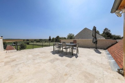 Table de ping-pong en extérieur devant un bâtiment en pierre avec une enseigne ’Le Loft de la Grange’.