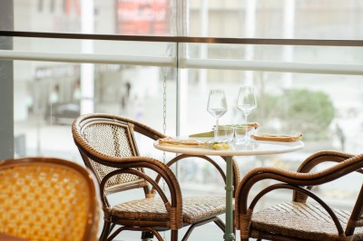 Miniature Location salle Paris 13 (Paris) - Rêva Brasserie BNF #11 Terrasse d'un restaurant avec des chaises en rotin, entourée de plantes en pot et située près d'un bâtiment moderne.