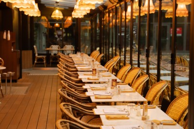 Miniature Location salle Paris 13 (Paris) - Rêva Brasserie BNF #7 Terrasse d'un restaurant avec des chaises en rotin, entourée de plantes en pot et située près d'un bâtiment moderne.