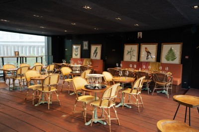 Miniature Location salle Paris 13 (Paris) - Rêva Brasserie BNF #7 Terrasse d'un restaurant avec chaises en rotin, située sur un trottoir bordé de plantes fleuries.