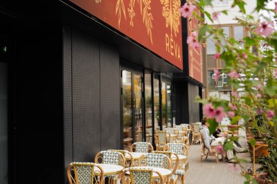 Miniature Location salle Paris 13 (Paris) - Rêva Brasserie BNF #12 Terrasse d'un restaurant avec chaises en rotin, située sur un trottoir bordé de plantes fleuries.