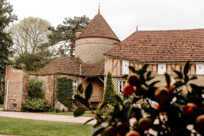 Un groupe de personnes rassemblé dans la cour d'un bâtiment en pierre avec un ciel nuageux en arrière-plan.