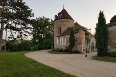 Un groupe de personnes rassemblé dans la cour d'un bâtiment en pierre avec un ciel nuageux en arrière-plan.