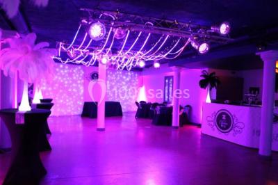 Groupe de personnes rassemblées dans une salle décorée avec des lumières et des guirlandes, lors d'une réception festive.